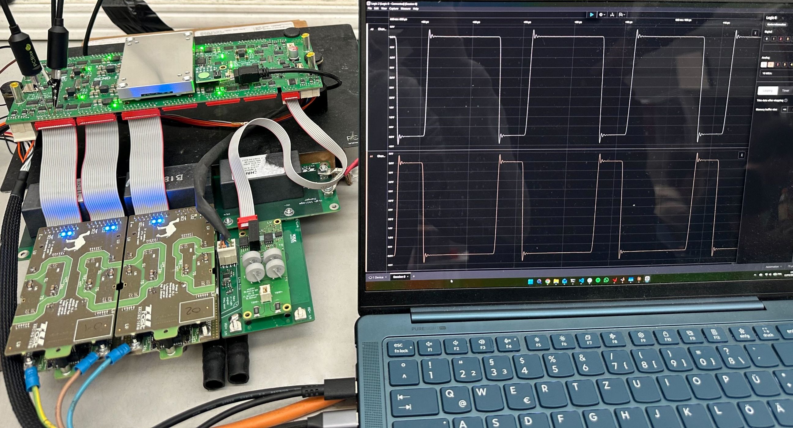Testaufbau der TUfast Motorsteuerung mit Leistungselektronik und dargestellten Messsignalen auf einem Laptop.