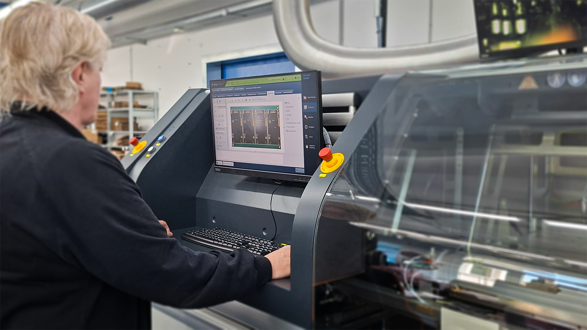 Person operating an electronics manufacturing system with a monitor for process supervision.